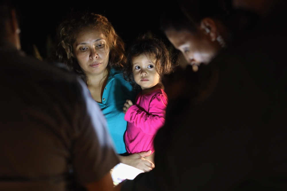 Central American asylum seekers including a Honduran girl aged 2 and her mother near the US-Mexico border in McAllen Texas on June 12, 2018. (AFP Getty Images North America / John Moore) 