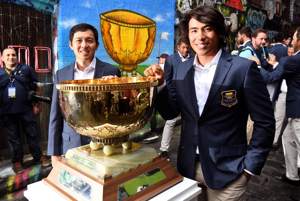Team Malaysia's Ben Leong (L) and Gavin Green pose with the World Cup of Golf trophy in Melbourne on November 20, 2018.  AFP / William West 