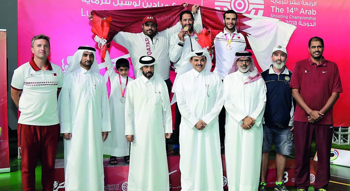 The podium winners at the 14th Arab Shooting Championship pose for a picture with officials at Losail Shooting Range yesterday.