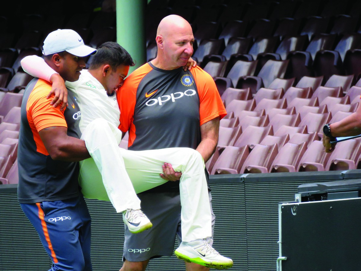 India's batsman Prithvi Shaw (C) is carried off after injuring his ankle whilst fielding on the third day of the tour match against Cricket Australia XI at the SCG in Sydney on November 30, 2018. AFP / Debasis Sen