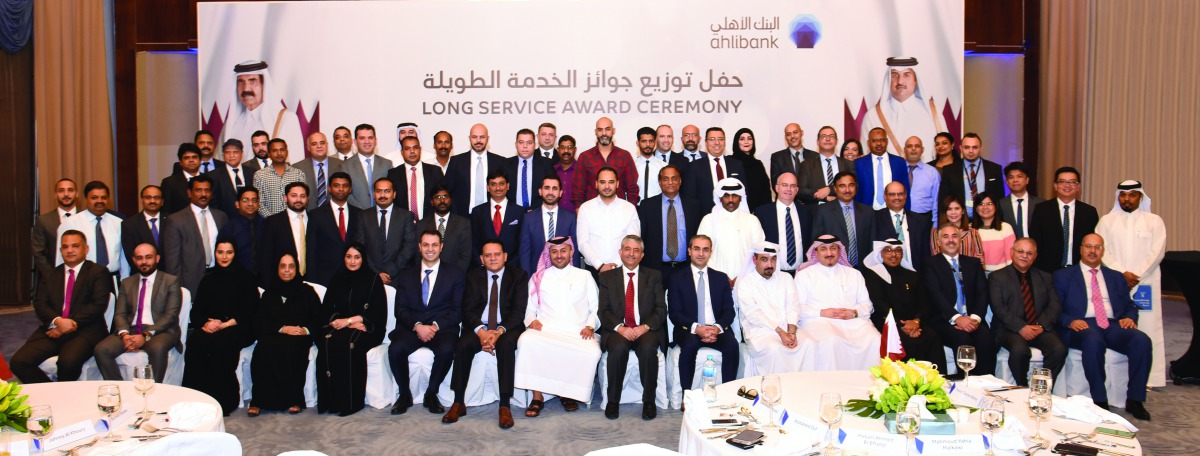 Top executives and senior employees of Ahlibank posing for a group photo to celebrate Qatar National Day and an award ceremony held to recognise its long-serving employees for their loyalty, commitment and dedication to the bank’s success, in Doha. 