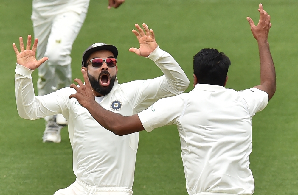  India's captain Virat Kohli (L) celebrates with spin bowler Ravichandran Ashwin (R) after beating Australia on day five of the first Test cricket match at the Adelaide Oval on December 10, 2018. / AFP / PETER PARKS