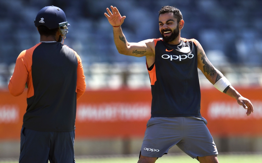 India's cricket captain Virat Kohli (R) shares a lighter moment with teammate Rishabh Pant (L) during a training session in Perth on December 12, 2018. AFP / William West 
