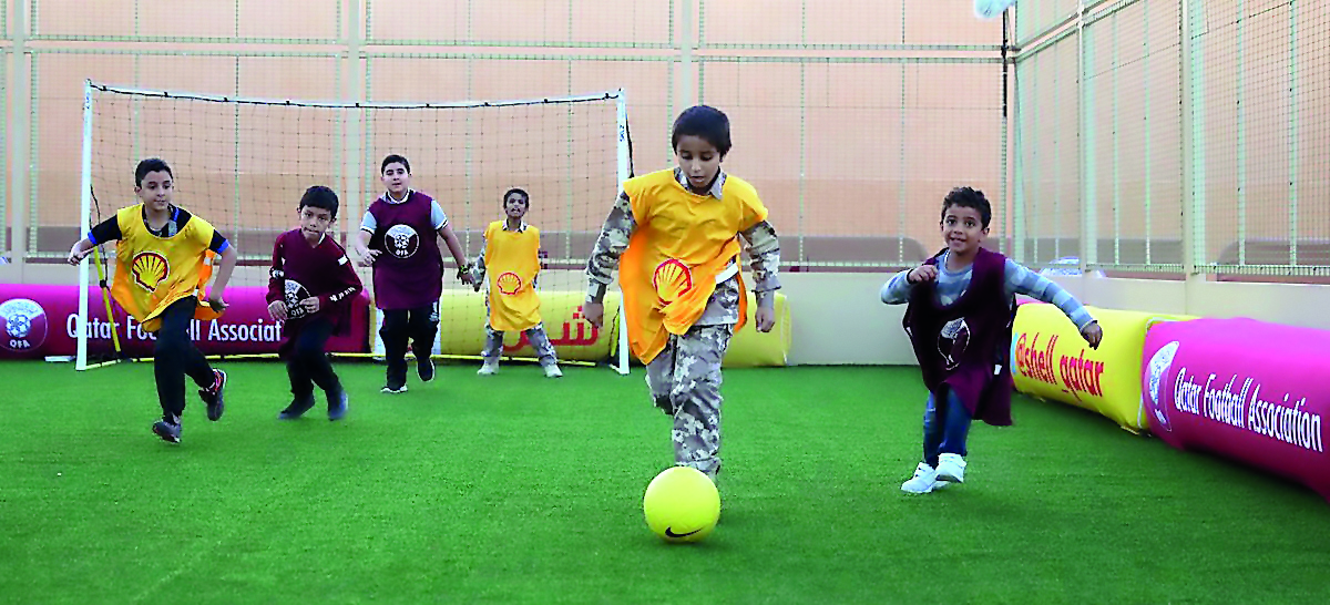 Young kids play football at the Qatar Football Association (QFA) pavilion at Darb Al Saai. 
