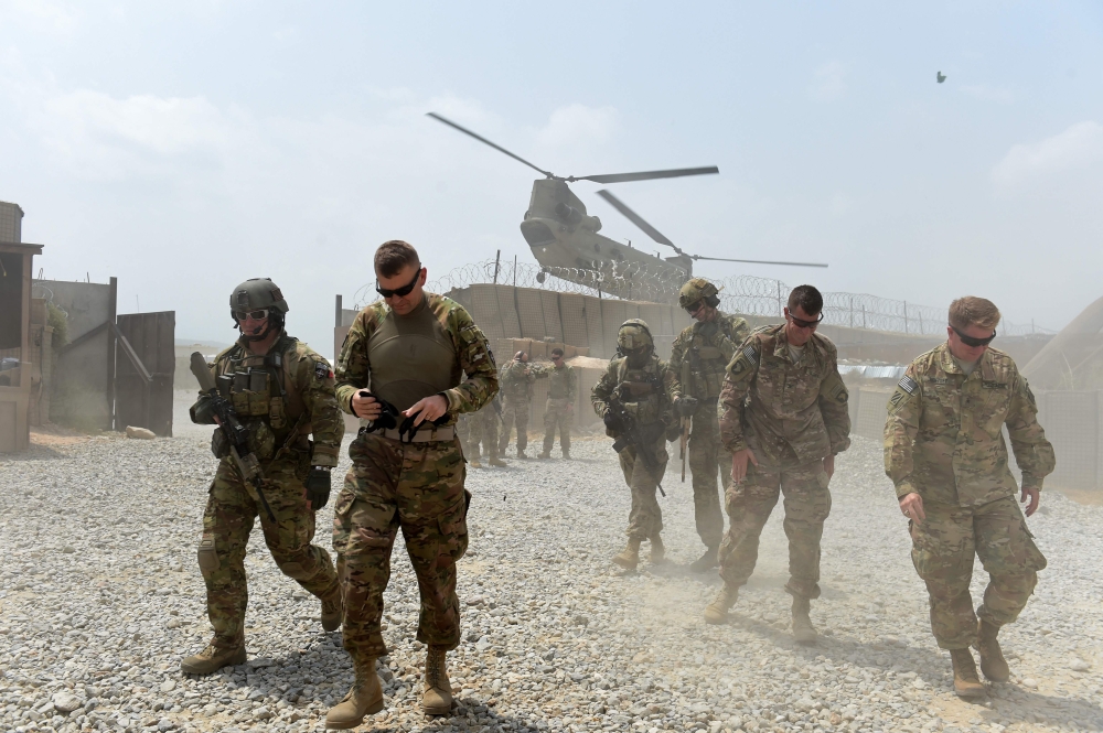 US army soldiers walk as a NATO helicopter flies overhead at coalition force Forward Operating Base (FOB) Connelly in the Khogyani district in the eastern province of Nangarhar, Afghanistan on August 12, 2015,  AFP / Wakil Kohsar
 

