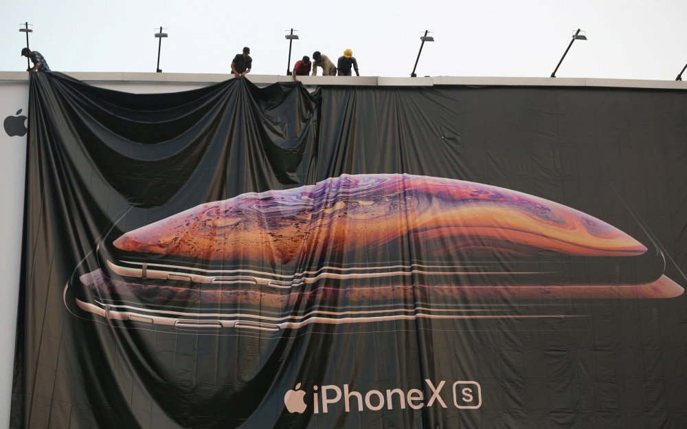 Workers adjust a hoarding of the newly launched iPhone XS in Ahmedabad, India October 4, 2018. (Reuters /Amit Dave/File Photo)