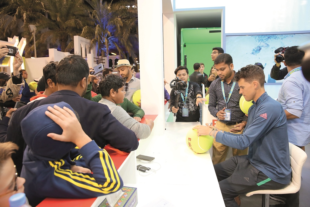 Dominic Thiem signs an autograph at the ExxonMobil Qatar Stand.