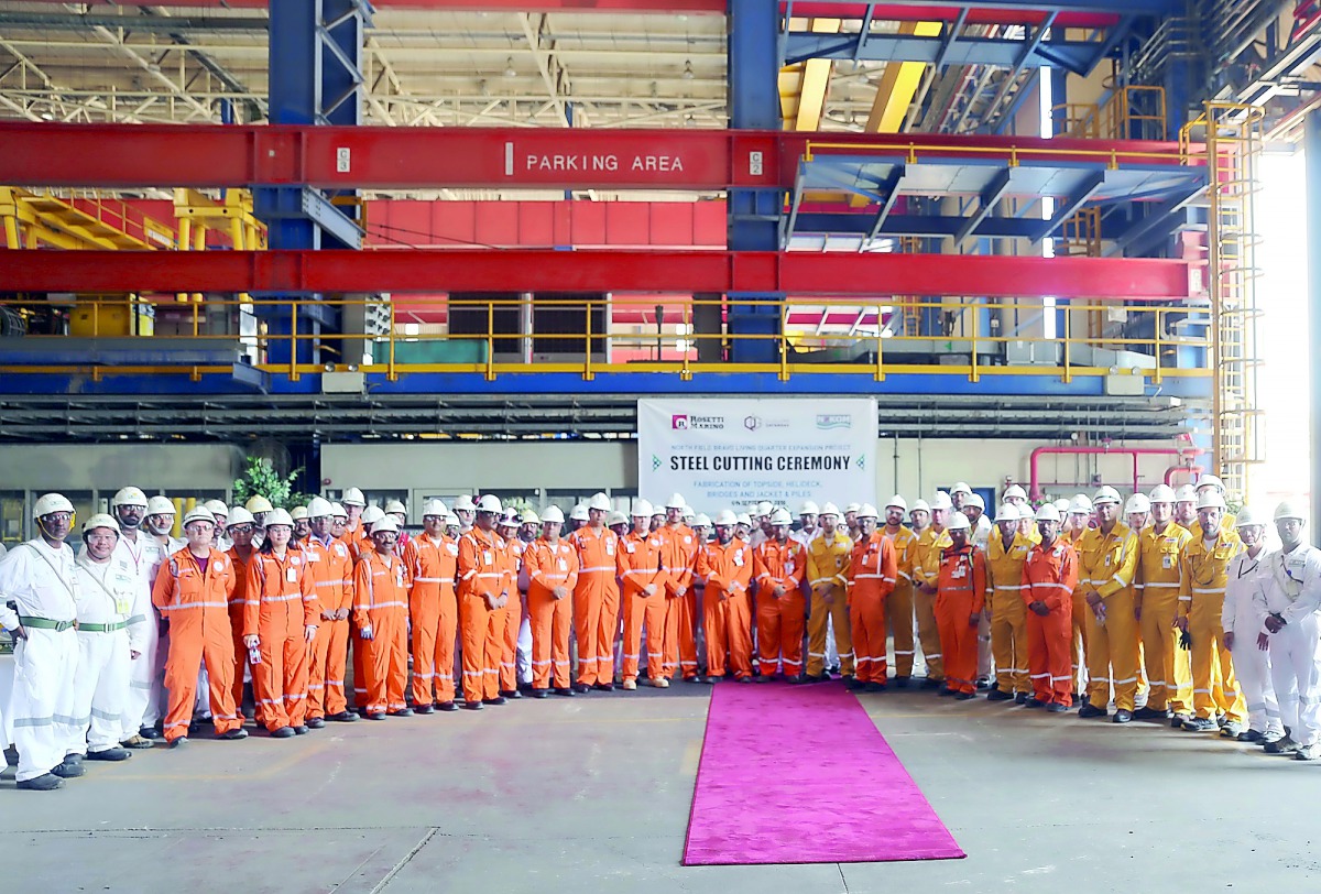 Employees of N-KOM posing for a group photo after marking the steel cutting ceremony for the first ever offshore living quarters to be fabricated in Qatar.