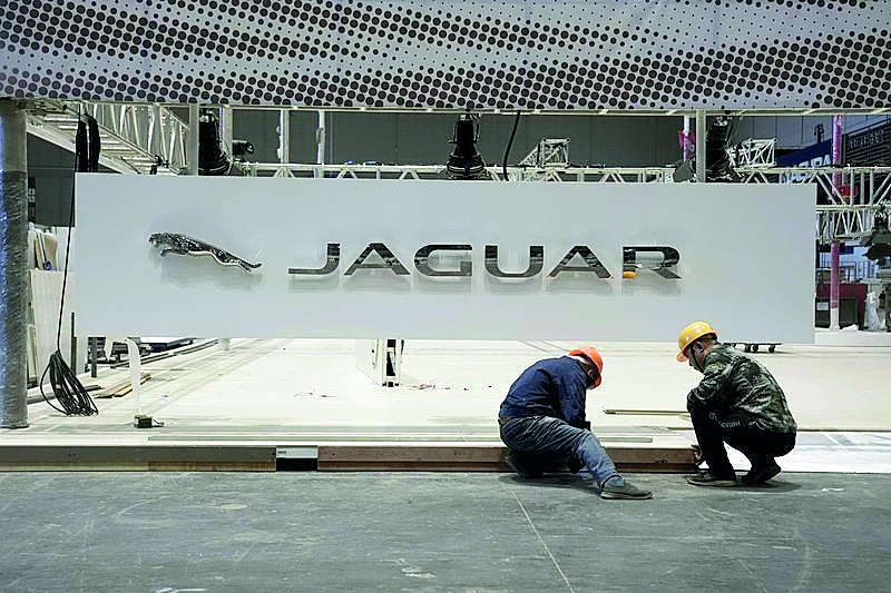 In this file picture, workers set up the booth for British car manufacturer Jaguar Land Rover’s Jaguar brand inside the National Exhibition and Convention Center, the venue for the recently held China International Import Expo (CIIE), in Shanghai, China. 