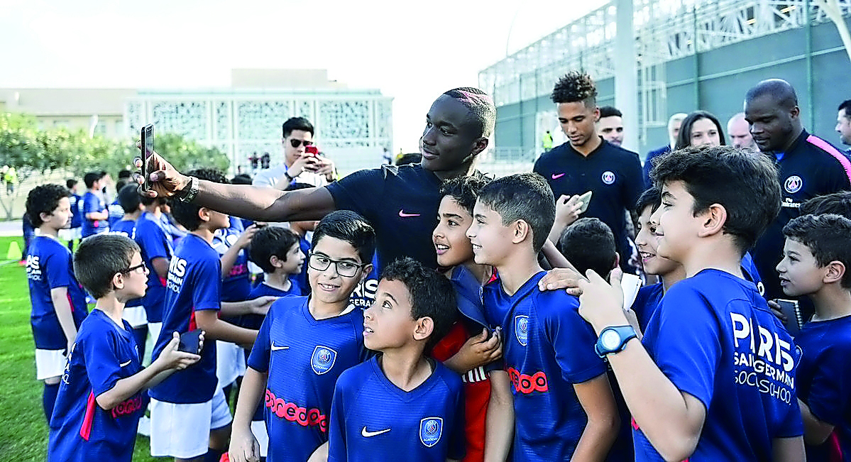 PSG forward Moussa Diaby takes a selfie with young kids during the inauguration ceremony of the club’s sports academy in Doha, yesterday. 