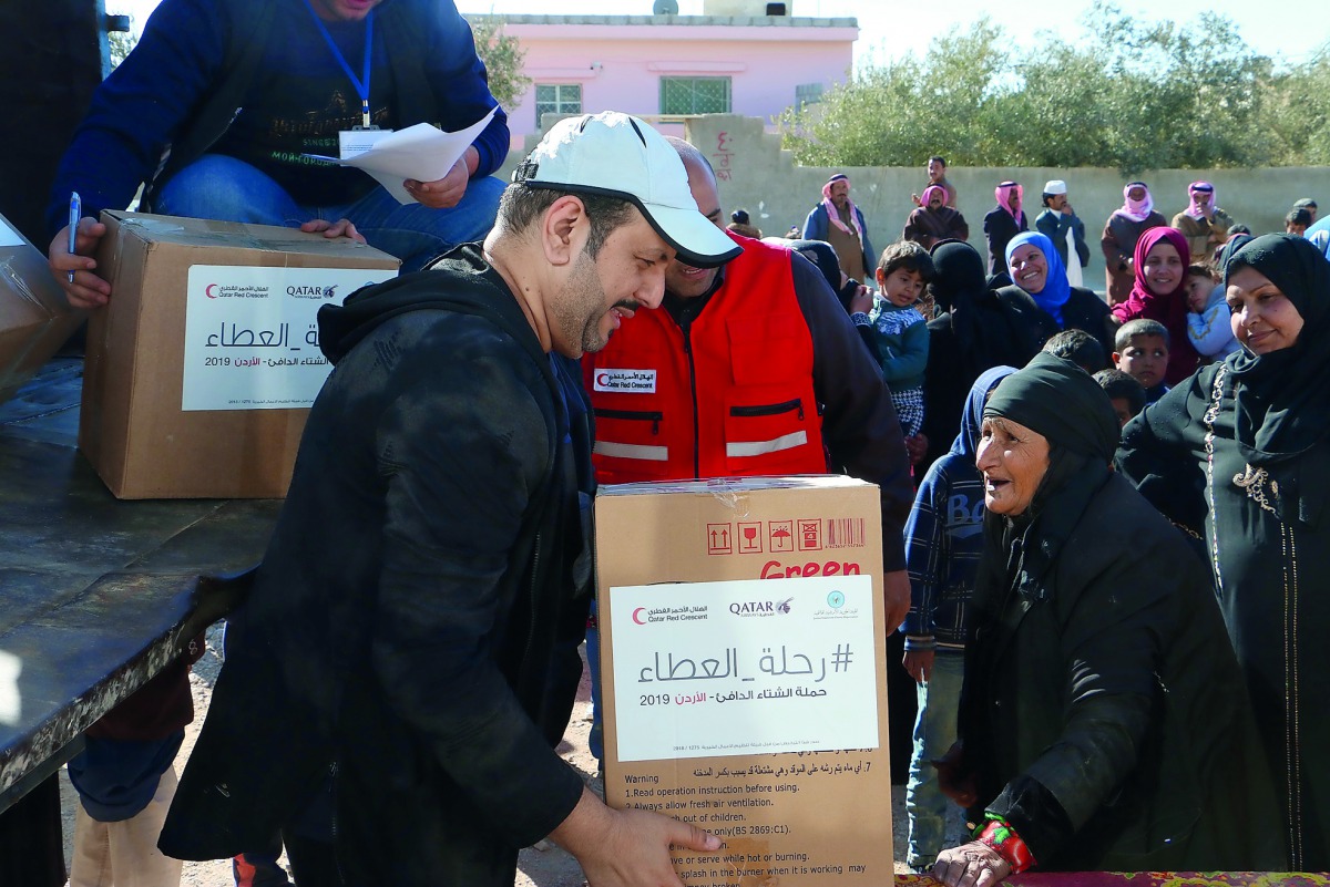 Qatar Red Crescent Society volunteers distributing aid. 