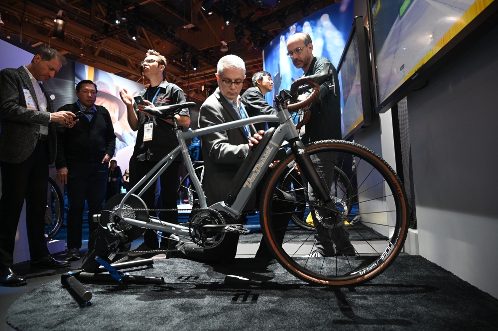 An attendee touches the batteries of a Van Dessel electric gravel bike, at the Panasonic booth at CES 2019 consumer electronics show, January 10, 2019 at the Las Vegas Convention Center in Las Vegas, Nevada. AFP / Robyn Beck 