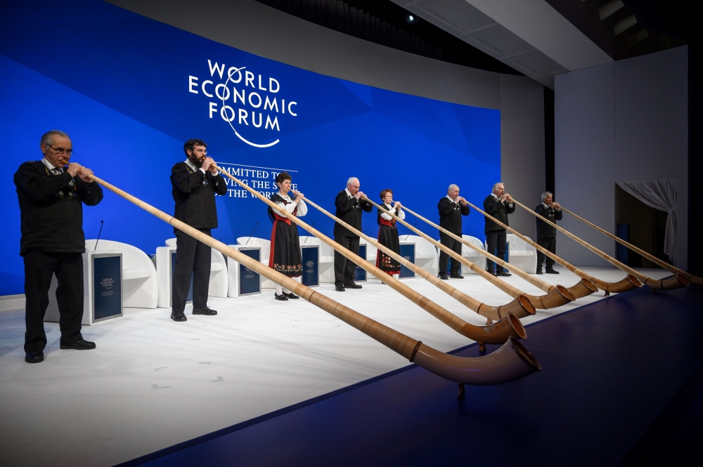 Alphorn blowers perform during the opening of the World Economic Forum (WEF) annual meeting, on January 22, 2019 in Davos, eastern Switzerland. / AFP / Fabrice COFFRINI