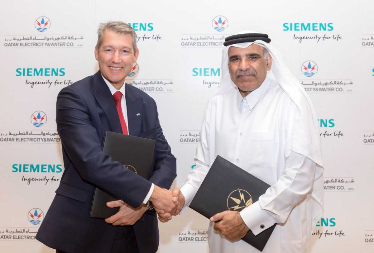 QEWC General Manager and Managing Director, Fahad bin Hamad Al Mohannadi (right), and Adrian Wood, Chief Executive Officer, Siemens Qatar, shaking hands after the signing ceremony.