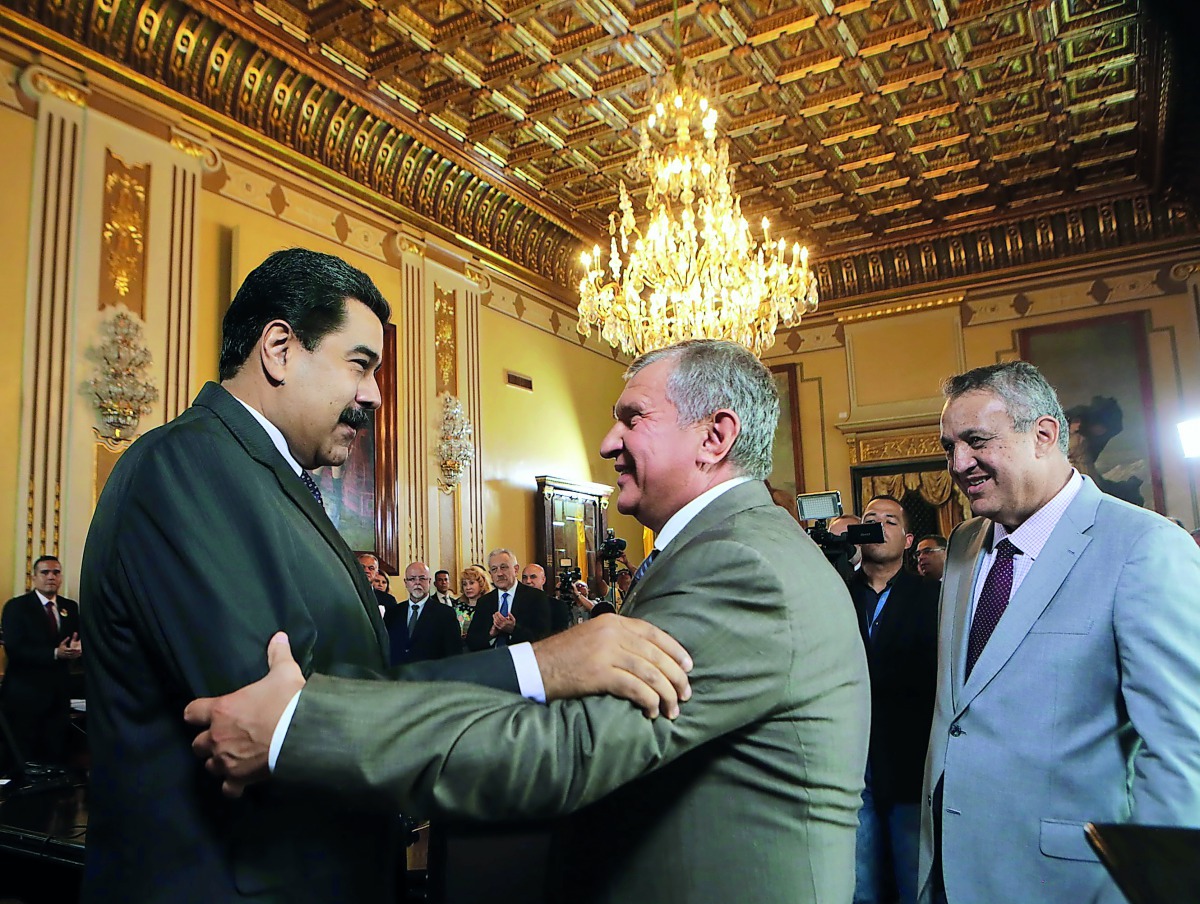 In this file photo of Venezuelan President Nicolás Maduro (left) and Igor Sechin, president of the Russian state-owned oil company Rosneft, exchanging greetings during a meeting in Caracas. Sechin is a frequent visitor to Venezuela for massive business in