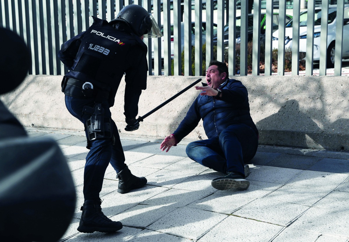 Police officer uses his baton on a striking taxi driver during a taxi strike against regulation of ride-hailing and car-sharing services such as Uber and Cabify in Madrid, Spain, January 24, 2019. Reuters/Susana Vera