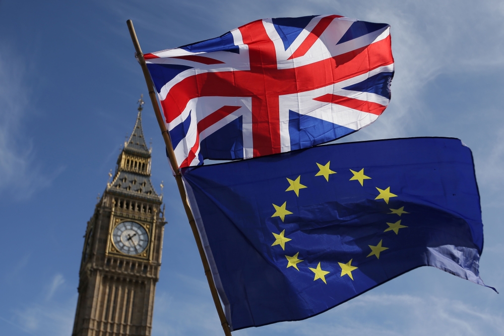 (FILES) In this file photo taken on March 25, 2017, an EU flag and a Union flag held by a demonstrator is seen with Elizabeth Tower (Big Ben) and the Houses of Parliament as marchers taking part in an anti-Brexit, pro-European Union (EU) enter Parliament 