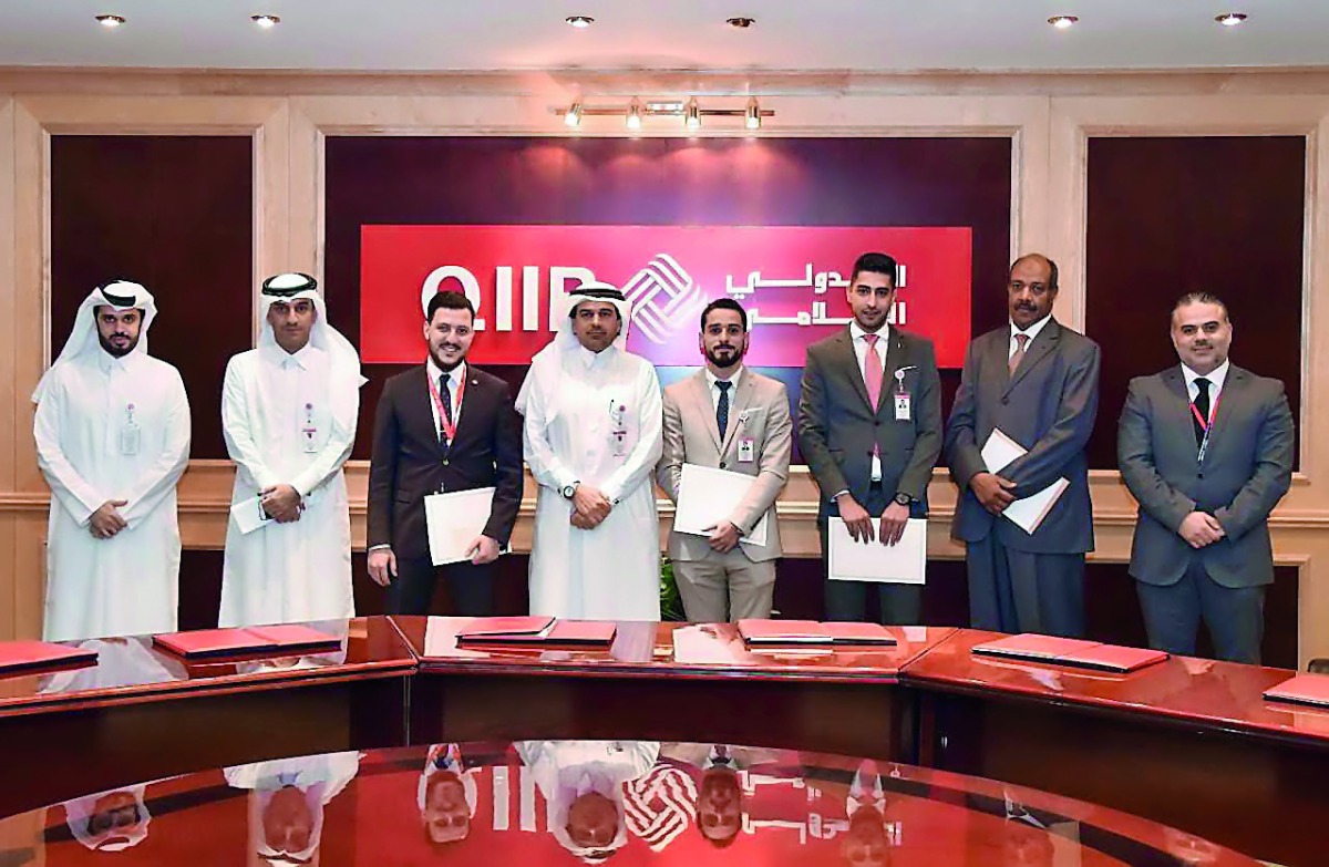 Dr Abdulbasit Ahmad Al Shaibei (fourth left), CEO, QIIB; and Jamal Abdullah Al Jamal (second left), Deputy CEO, QIIB, with other officials and top performing employees of QIIB, during the honouring ceremony.