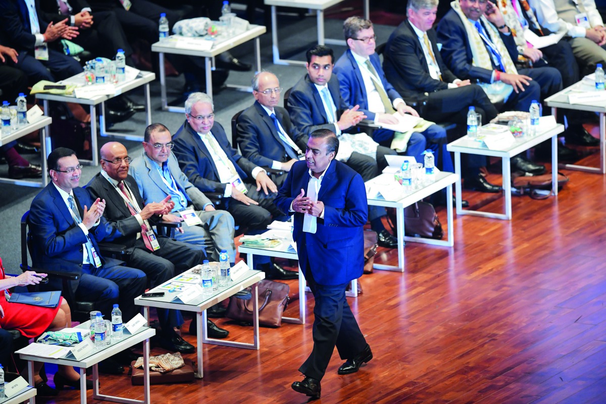 Indian businessman Mukesh Ambani (C) walks back to his seat after speaking to the audience at the Bengal Global Business Summit 2019 in Kolkata on February 7, 2019. AFP/Dibyangshu Sarkar