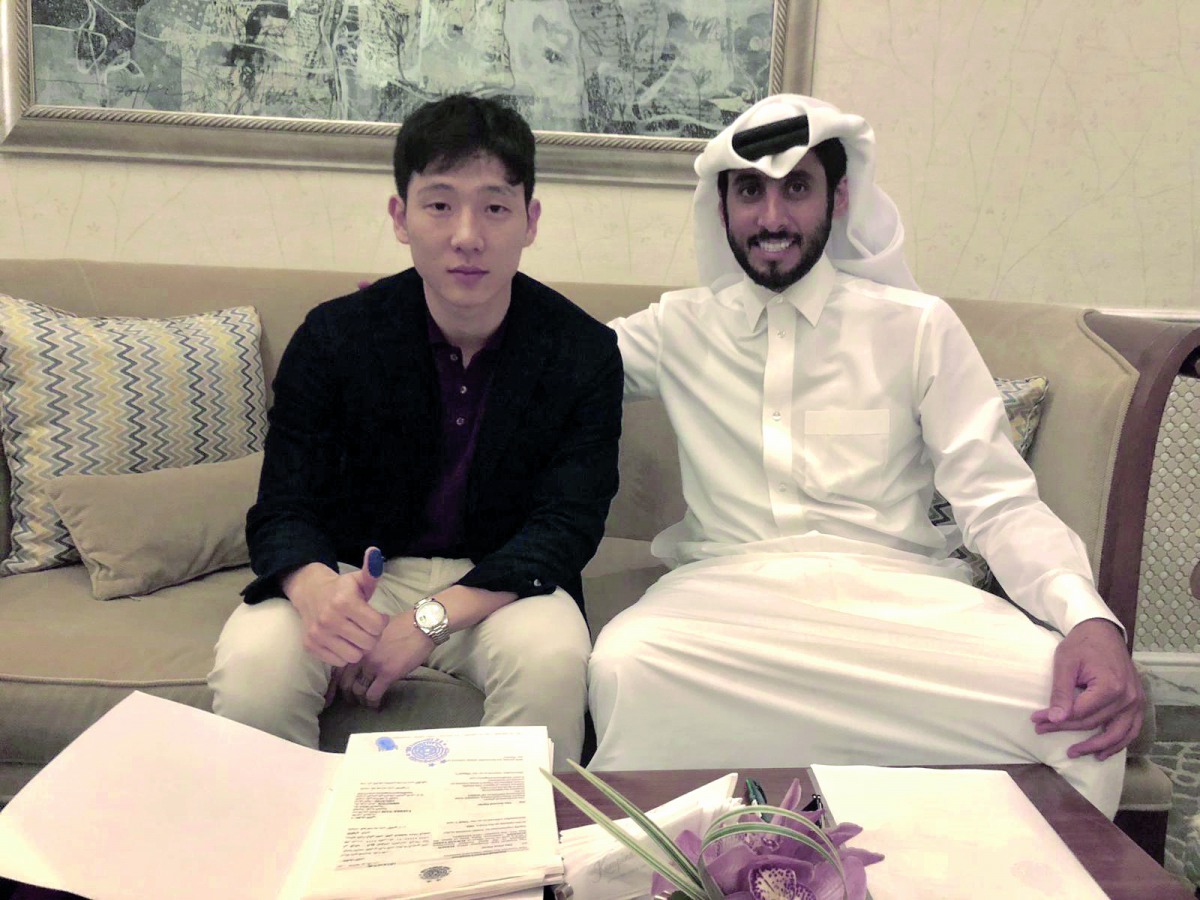 Nam Tae-hee (left) and Al Sadd SC’s General Manager, Turki Al Ali pose for a photograph after signing a three-year deal in Doha, yesterday.