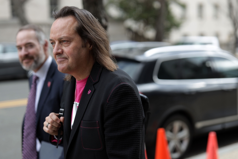 T-Mobile CEO John Legere (R) leaves after a hearing before the Communications and Technology Subcommittee of the House Energy and Commerce Committee February 13, 2019 on Capitol Hill in Washington, DC.  Alex Wong/Getty Images/AFP