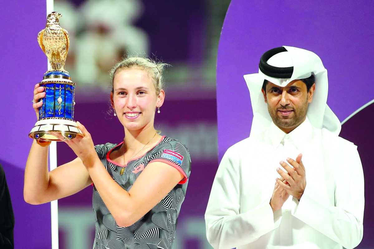 Champion Elise Mertens poses with the Qatar Total Open winner’s trophy on the podium next to President of the Qatar Tennis Federation Nasser Al Khelaifi, on Saturday.