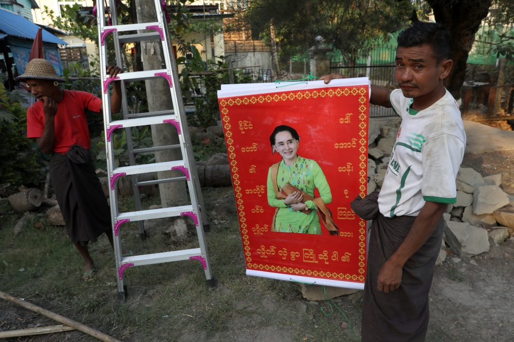 Workers put up poster of Myanmar's State Counsellor Aung San Suu Kyi ahead of the opening date of the Rakhine State Investment Fair in Ngapali beach in Thandwe, Rakhine, Myanmar February 20, 2019. Reuters/Ann Wang 