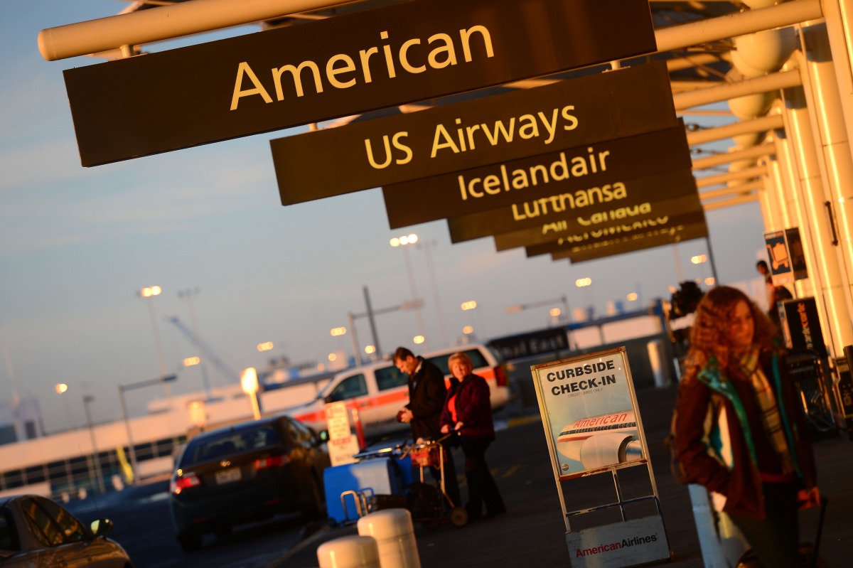 This December 9, 2013 photo shows American Airlines and US Airways signs stand next to each others at Denver International Airport, Colorado. AFP/Emmanuel Dunand