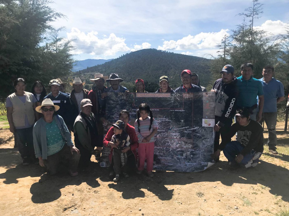 Residents of Tecoltemi indigenous land pose for a photo with a map of a mining project threatening their land in the town of Ixtacamaxtitlan, Mexico, Oct 30, 2018. Thomson Reuters Foundation/Karla Mendes 