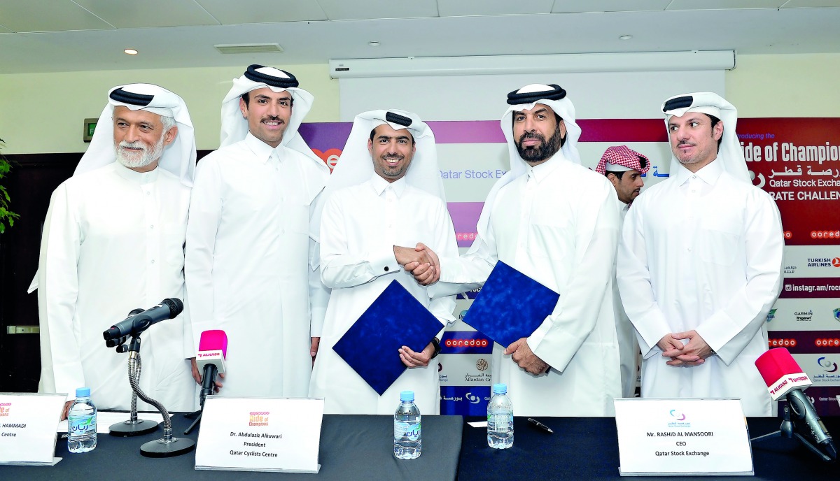 Dr Abdulaziz Al Kuwari (centre), President, Qatar Cycling Centre (QCC); and Rashid Ali Al  Mansoori, CEO, Qatar Stock Exchange (QSE), exchanging documents after the signing ceremony yesterday, as (from left) Abdullah Al Hammadi, from QCC; Ali bin Towar bi