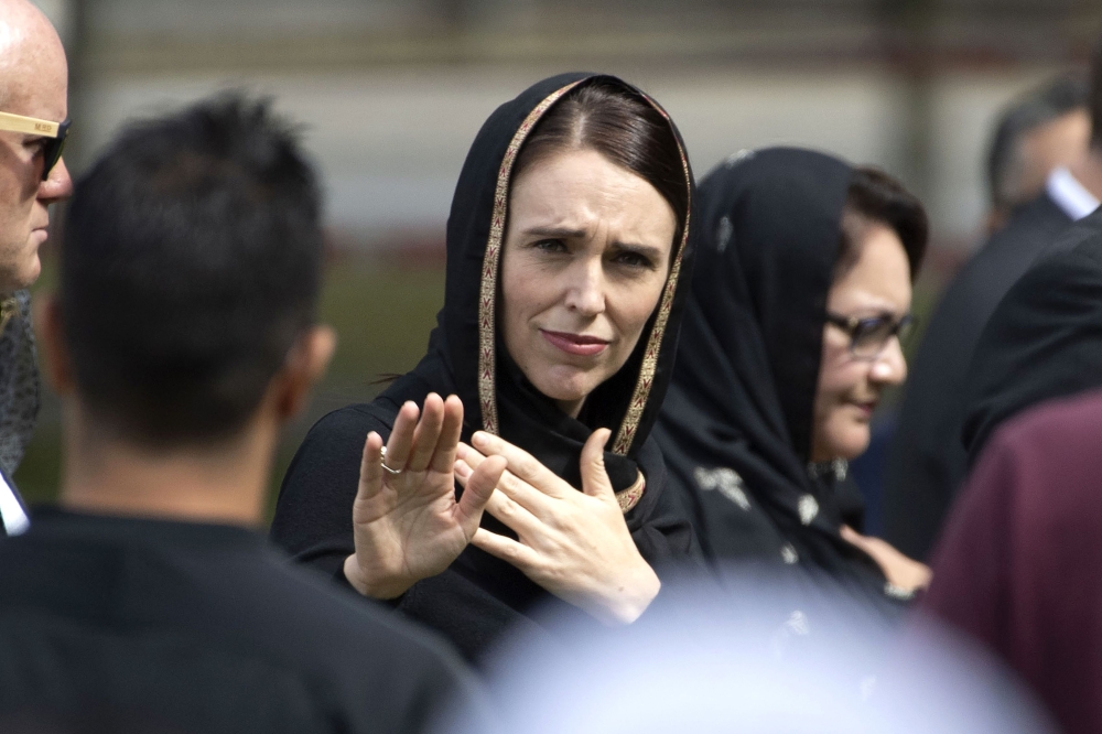 New Zealand's Prime Minister Jacinda Ardern gestures as she departs following a gathering for congregational Friday prayers and two minutes of silence for victims of the twin mosque massacre, at Hagley Park in Christchurch on March 22, 2019.  / AFP / Mart