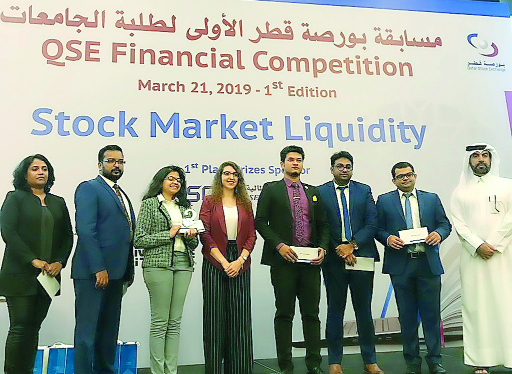 Rashid bin Ali Al-Mansoori, CEO of Qatar Stock Exchange, with students who participated in the competition.