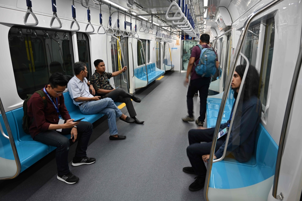 This picture taken on March 12, 2019 shows passengers on board a Jakarta mass rapid transit (MRT) coach during a trial run in the city.  AFP / Bay Ismoyo 