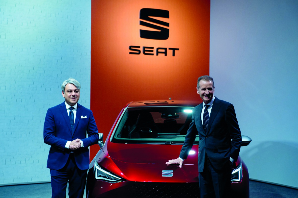 CEO of German car maker Volkswagen (VW) Herbert Diess (R) and Spanish automobile manufacturer Seat's president Luca de Meo pose in front of a SEAT car 