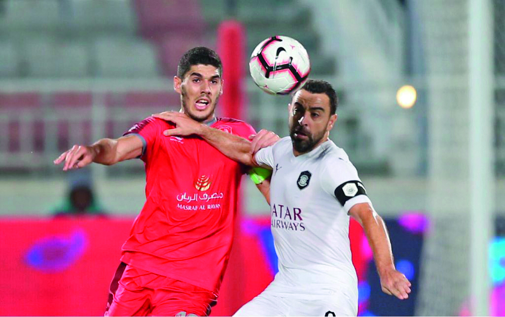 Al Duhail’s Karim Boudiaf (left) vies for the ball possession with Al Sadd’s captain, Spanish legend Xavi Hernandez during their QNB Stars League match played at the Al Duhail Stadium yesterday. 