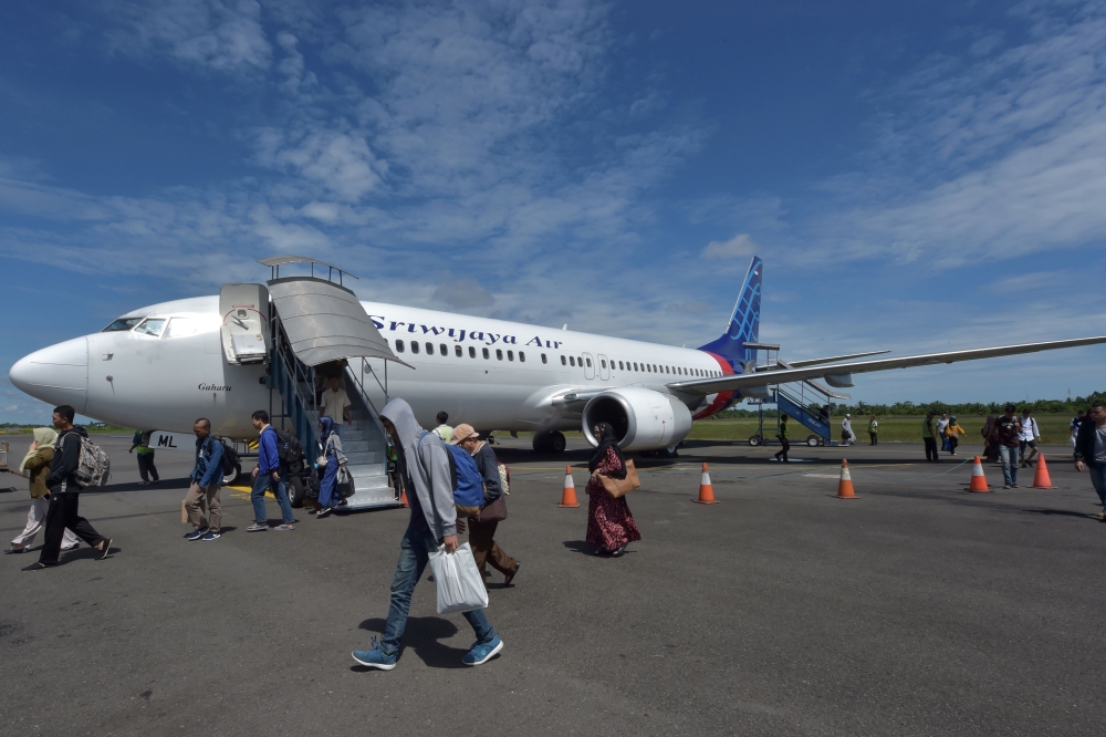 In this picture taken on June 1, 2018 passengers of a Sriwijaya Air flight disembark from the airplane at the Fatmawati airport in Bengkulu.  AFP / Adek Berry
 