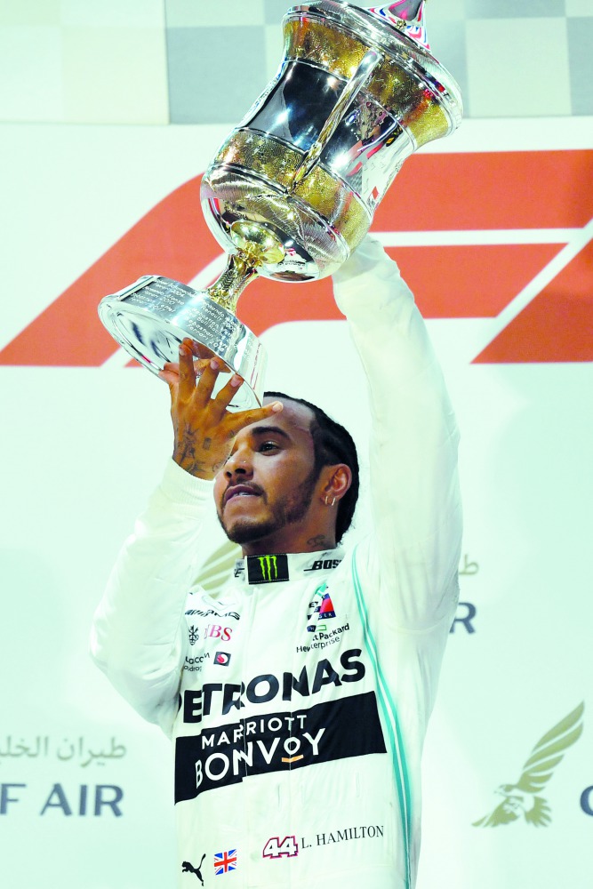Mercedes' British driver Lewis Hamilton (C) celebrates on the podium after winning the Formula One Bahrain Grand Prix at the Sakhir circuit in the desert south of the Bahraini capital Manama, on March 31, 2019. AFP / Andrej Isakovic

