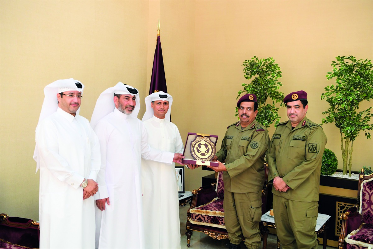QIB Senior officials receiving a plaque from the Amiri Guard officer. 
