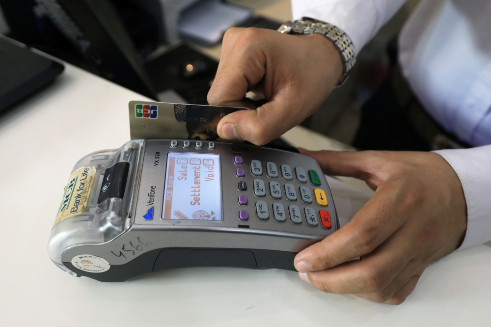A salesman registers a credit card for a customer at a shop in Peshawar, Pakistan April 1, 2019. Reuters/Fayaz Aziz