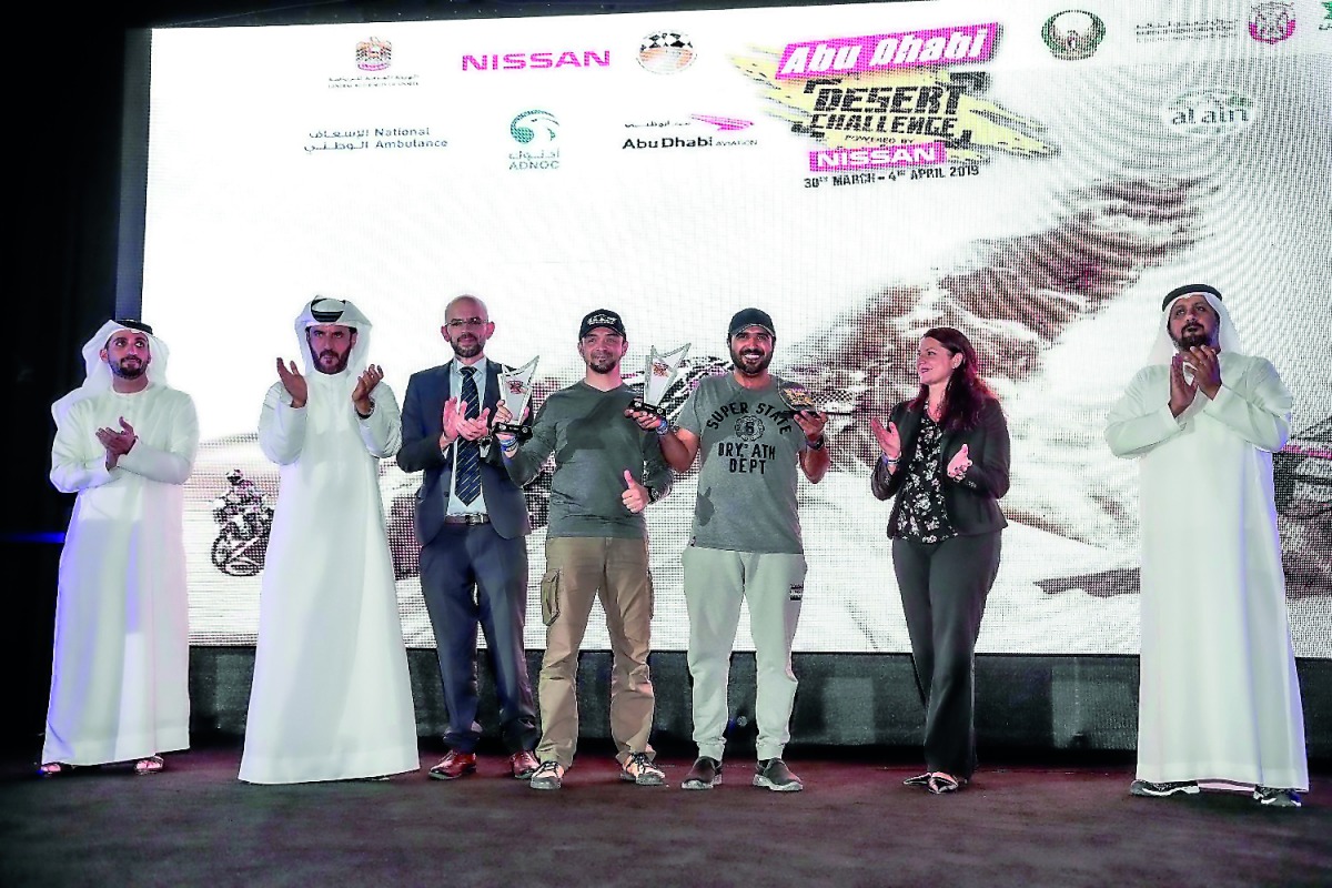 Qatari driver Mohammed Al Meer (second right) and his Russian co-driver Alexey Kuzmich (centre) celebrate with the trophies during the presentation ceremony of the 29th Abu Dhabi Desert Challenge, powered by Nissan at Yas Marina Circuit on Thursday. Al Me