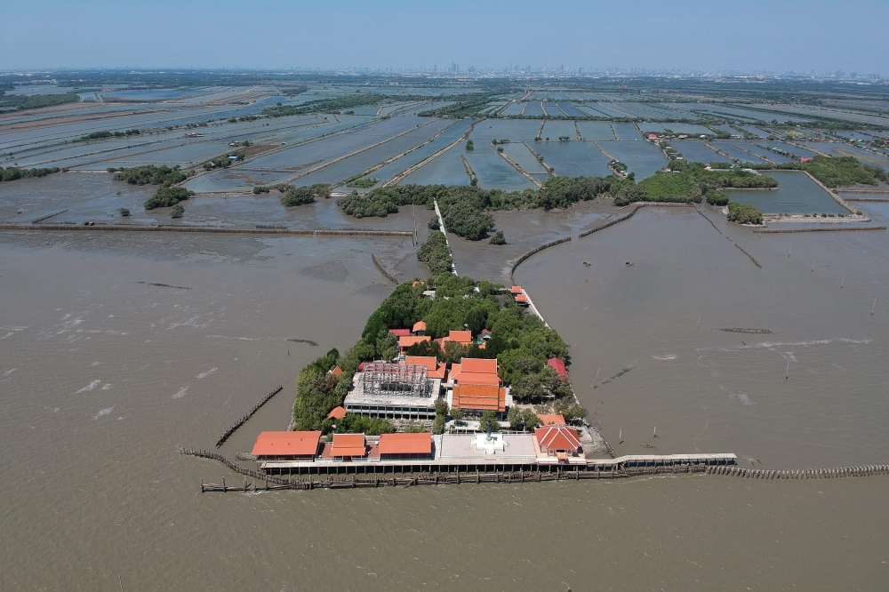 This aerial photo taken on March 9, 2019 shows a view of a Buddhist temple isolated by coastal erosion in Samut Chin village, off the shore of Samut Prakan. AFP / Jonathan Klein
