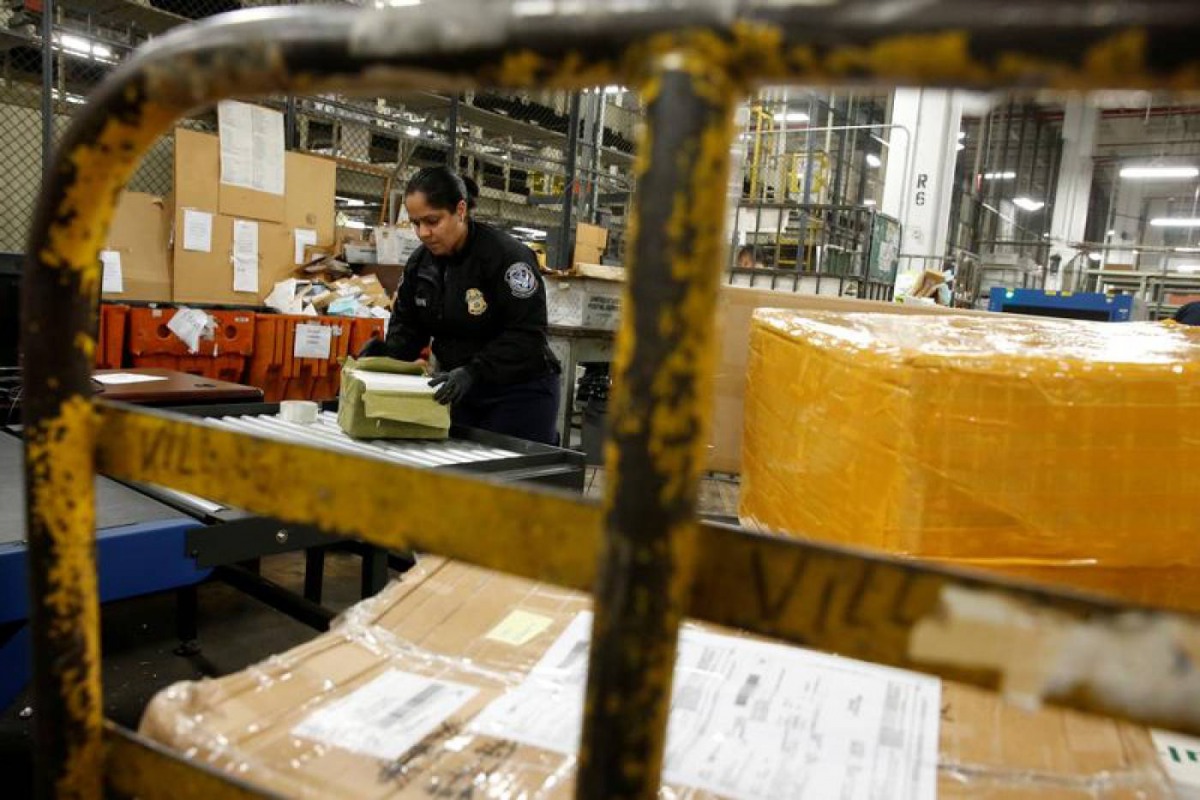 US Customs and Border Protection officer opens packages at the JFK mail facility in New York,  August 28, 2018. Reuters/Jill Kitchener