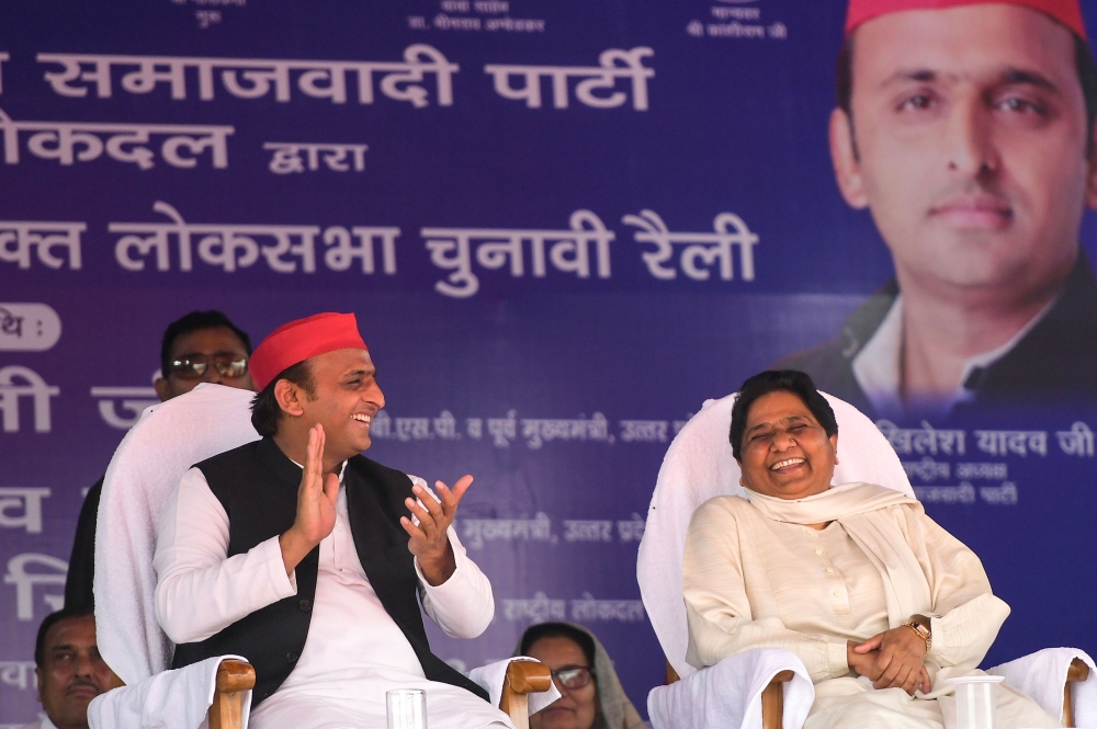 Indian Samajwadi Party (SP) president Akhilesh Yadav (L) and Bahujan Samaj Party (BSP) president Mayawati (R) applaud and laugh at the SP-BSP-RLD alliance's first joint rally in Deoband in Uttar Pradesh state on April 7, 2019. AFP / Sanjay Kanojia