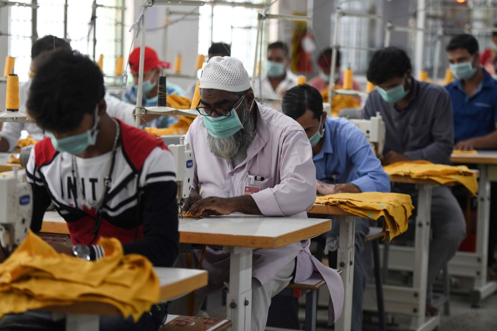 Indian labourers stitch apparel in the tailoring section of a textile production unit in the south Indian city of Tiruppur on March 25, 2019. AFP / Arun Sankar