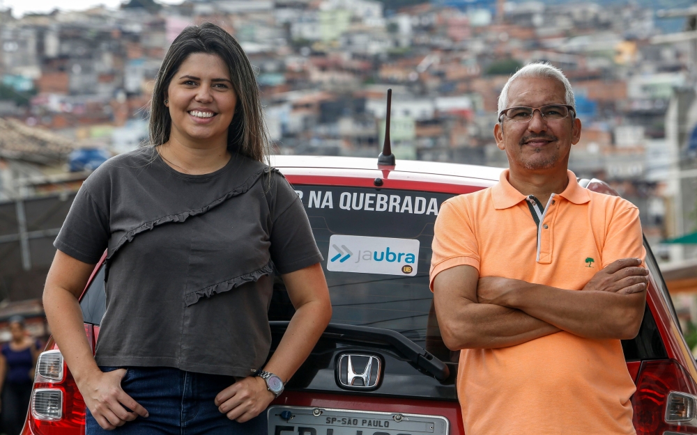 Brazilian Alvimar da Silva (R), creator of the JaUbra (Uber of slum) private transportation service, poses next to his daughter Aline Landim in Brasilandia, northern outskirts of Sao Paulo, Brazil, on February 27, 2019. AFP / Miguel Schincariol 