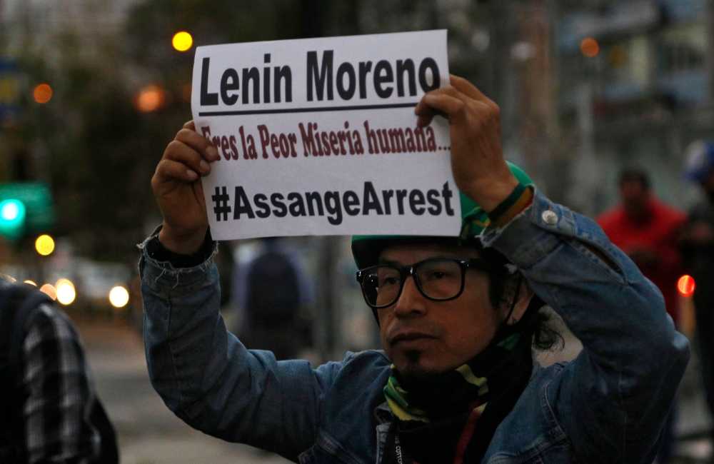 A man holds a placard against Ecuadoran President Lenin Moreno as he demonstrates against the arrest of WikiLeaks founder Julian Assange in front of the Foreign Ministry in Quito on April 11, 2019. AFP / Cristina VEGA