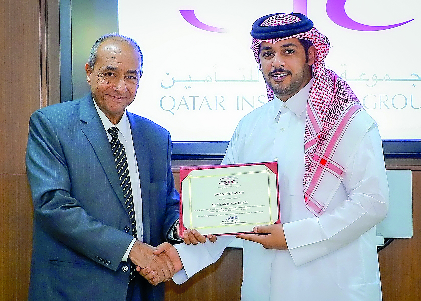 Ali Derbala (left) receives a certificate from Salem Al Mannai, Deputy Group President & CEO of QIC Group, at the award ceremony held at QIC headquarters in West Bay. 