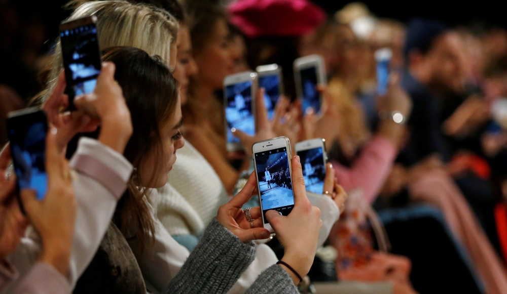 A so-called media influencer takes pictures at Berlin Fashion Week, January 19, 2017. Reuters/Hannibal Hanschke