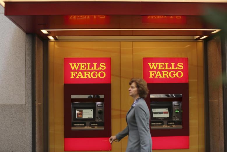 A woman walks past teller machines at a Wells Fargo bank in San Francisco in this October 10, 2013 file photo. Reuters/Robert Galbraith