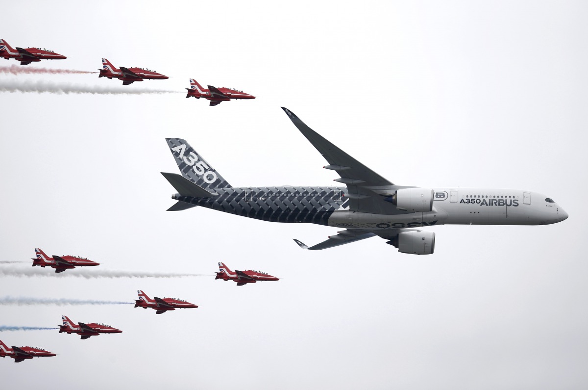 An Airbus A350 aircraft flies in formation with Britains’ Red Arrows flying display team at the Farnborough International Airshow in Farnborough, July 15, 2016. Reuters/Peter Nicholls